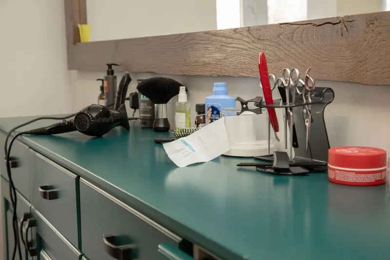 A well-organized salon workspace featuring essential hair styling tools on a cabinet
