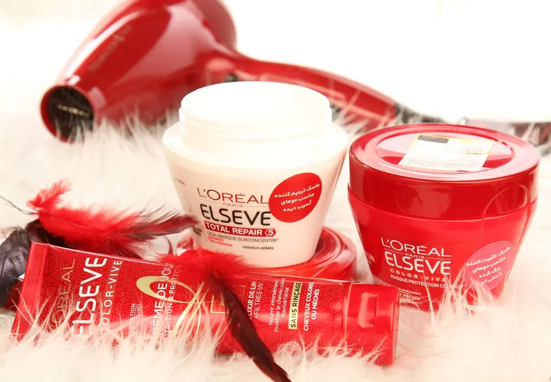 High-quality shot of L'Oreal hair products and hair dryer on white fur background